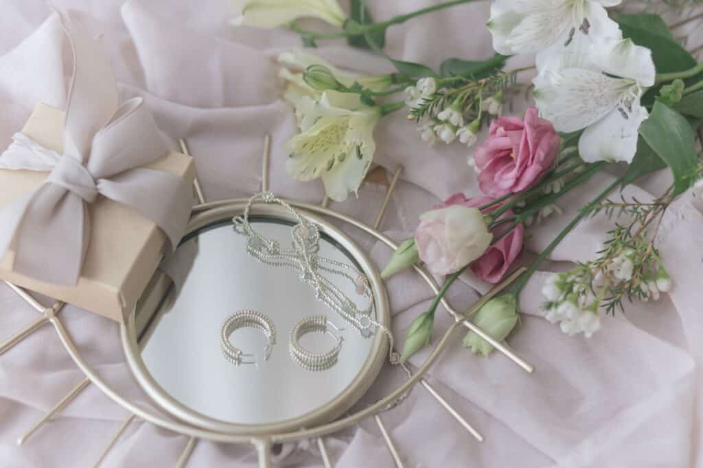 stylish gift box, modern jewelry, spring bouquet on boho mirror